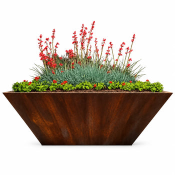 Modern rust-finish rectangular tapered metal planter with vibrant red flowers, blue-green ornamental grasses and lush green foliage on a white background.